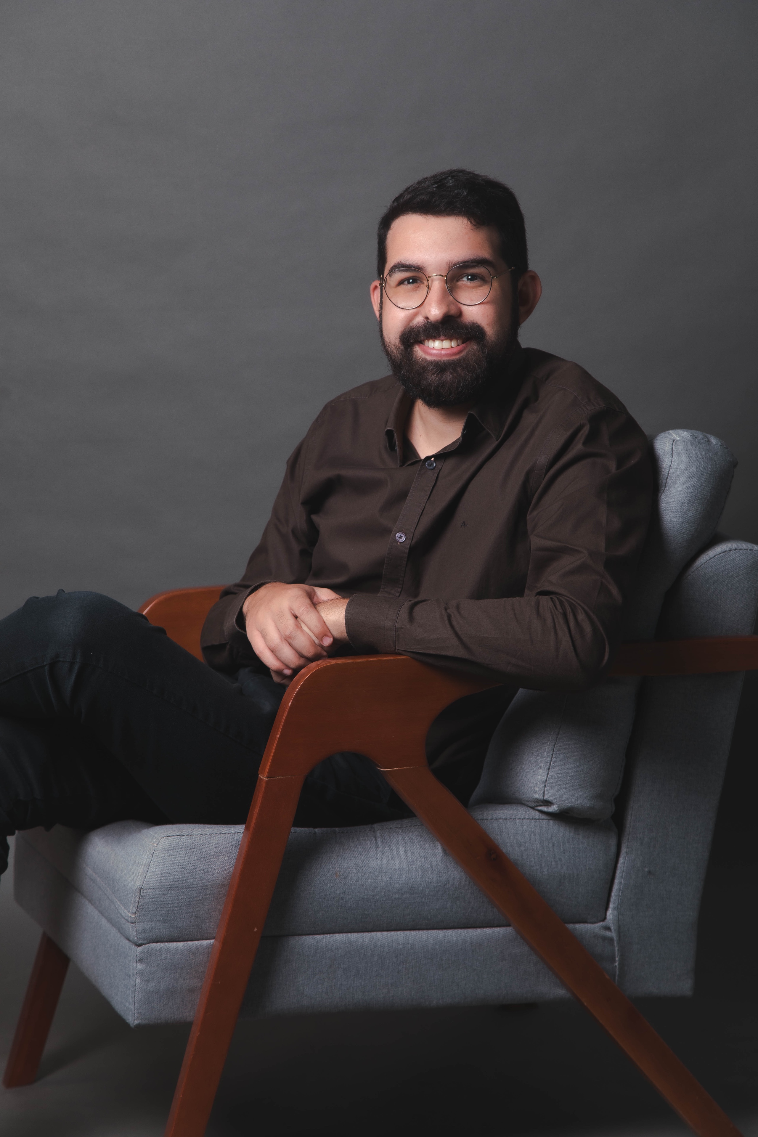 Dr. Matheus Gomes sentado em consultório